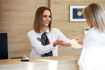Hotel front desk agent discussing room upgrade options with a guest during check-in